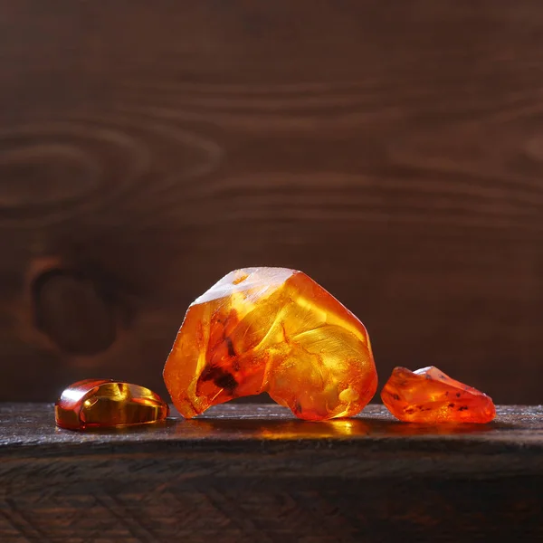 Brillantes Piedras Ámbar Sin Tratar Sobre Fondo Madera Retroiluminado Por —  Fotos de Stock