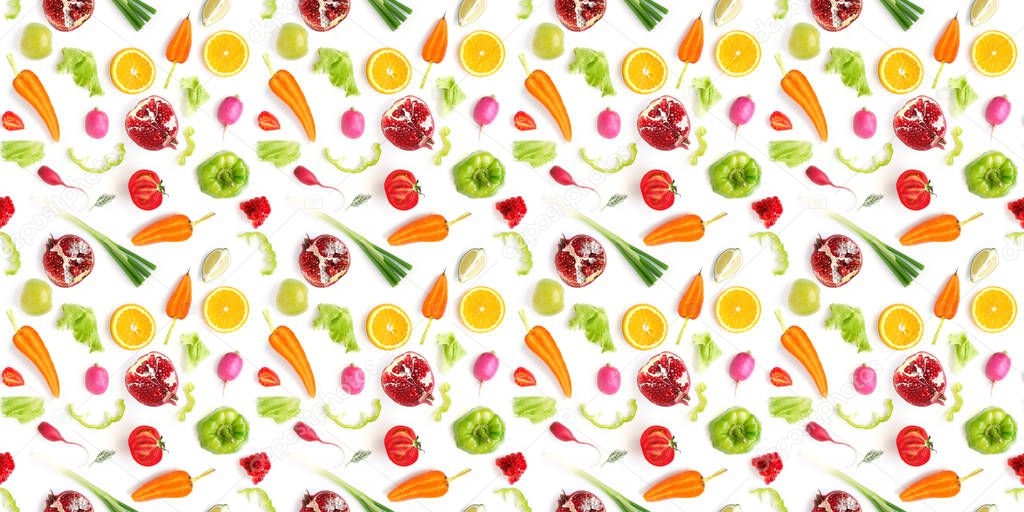 Vegetable composition with parted carrots, garnets, strawberries, tomatoes, sliced peppers, green leaves, oranges, limes ana whole young onions, radishes on white background 