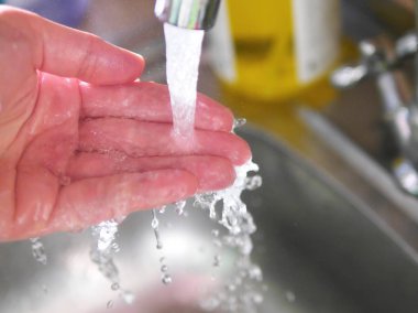 Mutfak musluk suyu altında el görünümünü kapat 