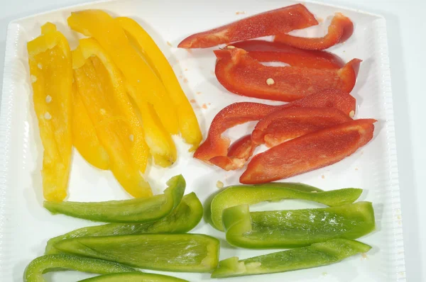 Preparation in the kitchen of three peppers for a colorful dish — Stock Photo, Image