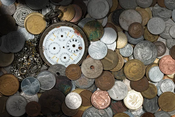 Зламаний кишеньковий годинник зі старими монетами — стокове фото