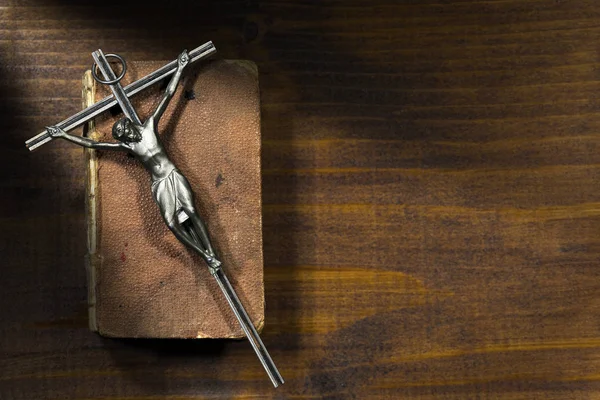 Серебряное распятие и Священная Библия на деревянном фоне — стоковое фото