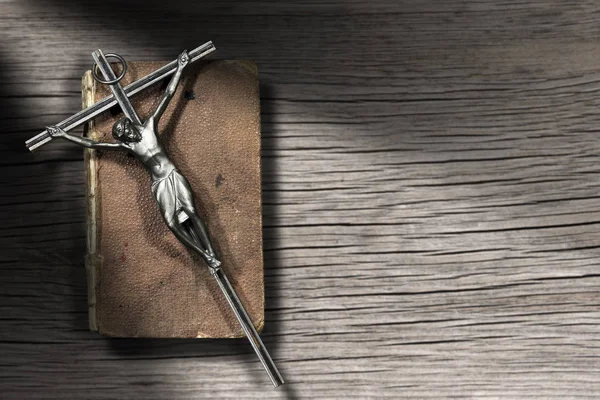 Серебряное распятие и Священная Библия на деревянном фоне — стоковое фото