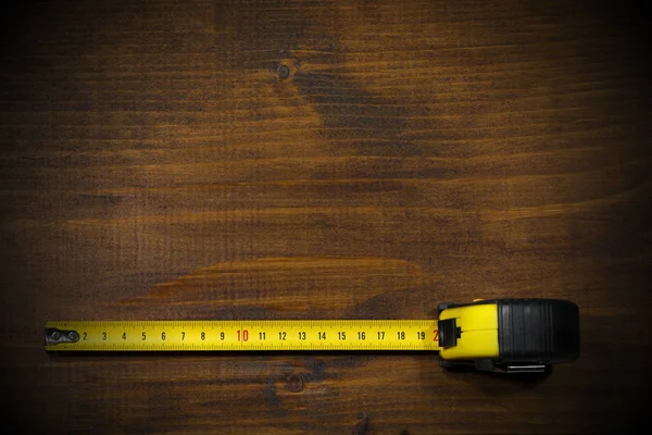 Medida de cinta en una mesa de trabajo de madera — Foto de Stock