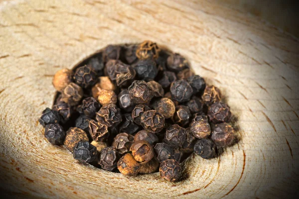 Peppercorns en un fondo de madera — Foto de Stock