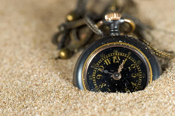 Pequeño reloj de bolsillo en la arena — Foto de Stock