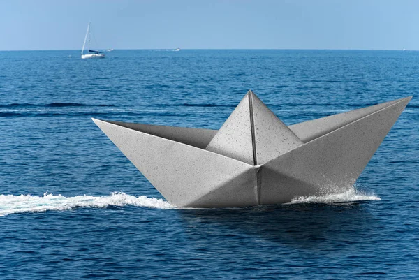 Barco de papel branco corre rápido sobre o mar azul com esteira — Fotografia de Stock