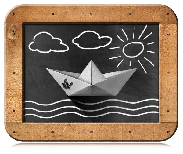 Бумажная лодка, плавающая в море - Доска с иллюстрацией мелом — стоковое фото