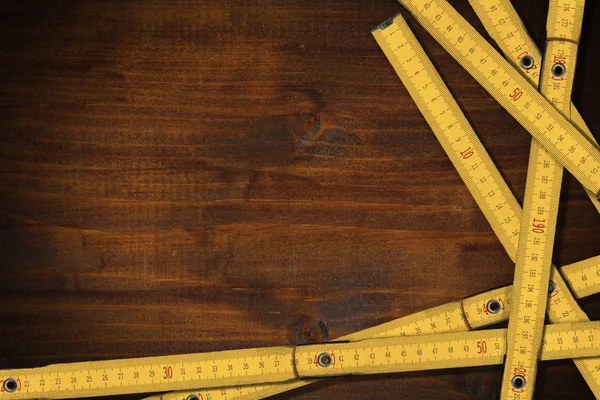 Reglas amarillas plegables de madera sobre una mesa de trabajo con espacio para copiar — Foto de Stock