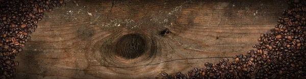 Grãos de café torrados em um velho fundo de madeira — Fotografia de Stock