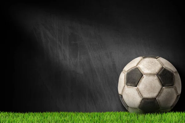 Bola de futebol velho na grama verde com quadro-negro vazio — Fotografia de Stock