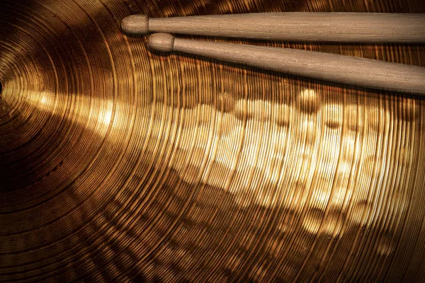Nahaufnahme von hölzernen Drumsticks auf einem goldenen Becken — Stockfoto