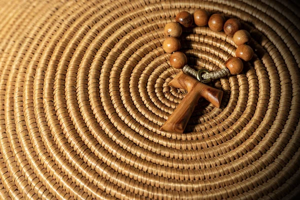 Tau - Wooden Cross and Rosary Bead on woven wicker texture — Stock Photo, Image