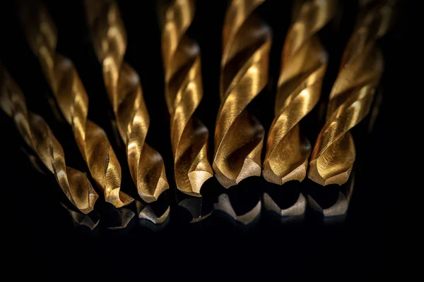 Goldene Bohrspitzen auf schwarzem Hintergrund - selektiver Fokus — Stockfoto
