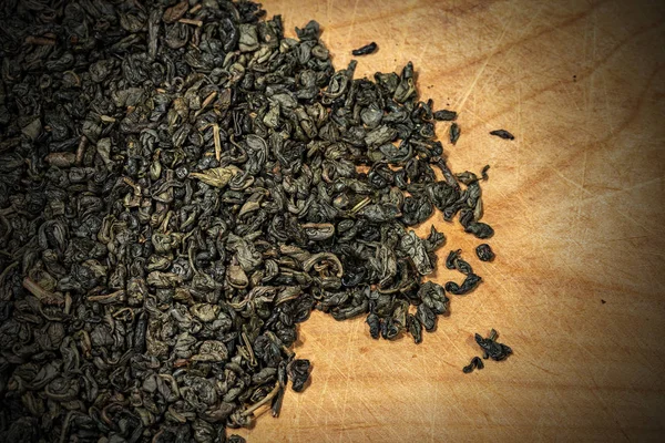 Hojas secas de té verde de pólvora sobre fondo de madera — Foto de Stock
