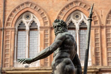 Bronze statue of Neptune (1566), Roman God, fountain in Piazza del Nettuno, and Palazzo d'Accursio, Town hall in downtown of Bologna (XIII century). Emilia-Romagna, Italy, Europe. Artist Giambologna (1529-1608) clipart