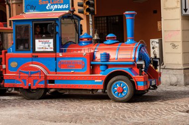 BOLOGNA, EMILIA-ROMAGNA, ITALY, - FEB 23, 2020: Closeup of a small tourist train with rubber wheels called San Luca Express to take a sightseeing tour in Bologna downtown. Italy, Europe.