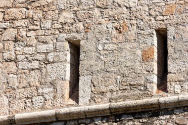 Ortaçağ kale duvarının iki ok deliği ya da boşluğu olan yakın çekimi. Trento şehrinde Castello del Buonconsiglio veya Castelvecchio. Trentino Alto Adige, İtalya, Avrupa