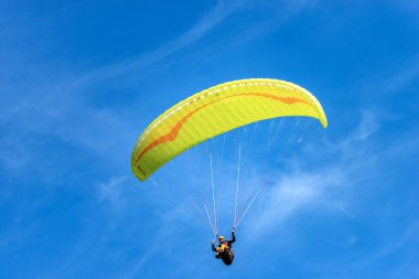 SCHWANGAU, ALMANY - 9 SEP 2018: Sarı ve turuncu paraglider, arka planda bulutlarla mavi gökyüzünde uçuyor. Schwangau, Bavyera, Almanya