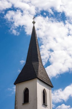 Avusturya 'da Oberschutt, Villach, Carinthia, Avusturya, Avrupa' daki küçük bir köyde bulunan tipik bir çan kulesine yakın plan. St. Mary Magdalene Kilisesi