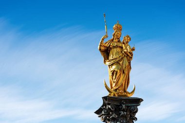 Mariensaule Marienplatz, Münih, Almanya 'da. Bakire Meryem 'in altın heykeli ve mavi gökyüzünde bulutlu bebek İsa (1590). Bavyera, Almanya, Avrupa