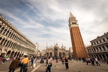 Katedral bazilikası ve çan kulesi (campanile) ile Saint Mark Meydanı (Piazza San Marco). Turist grupları gezer ya da kafede otururlar. Venedik, İtalya, Avrupa