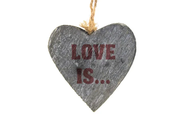 Ізольоване дерев'яне серце зі словом Love IS — стокове фото