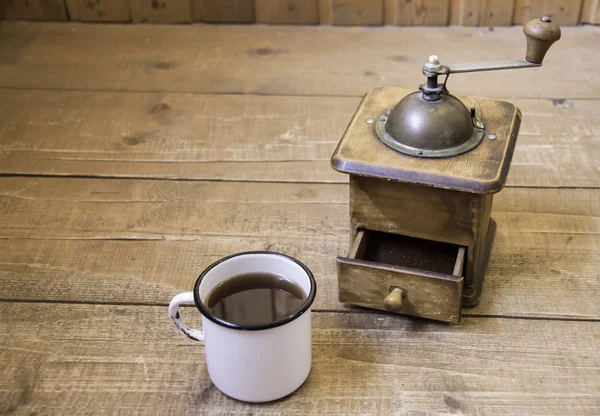 Molinillo de café manual vintage y una taza de café en una superficie de madera — Foto de Stock