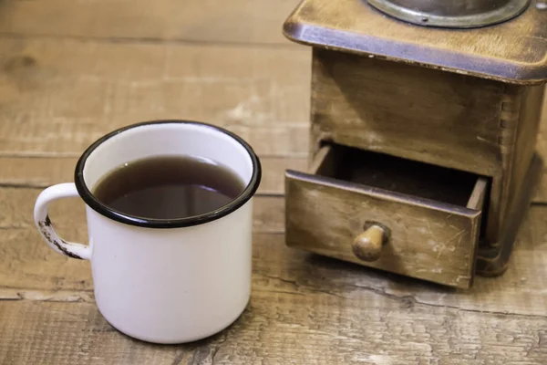 Molinillo de café manual vintage y una taza de café en una superficie de madera — Foto de Stock