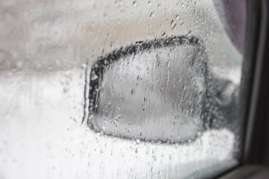 Arabanın yağmurlu pencereden yan aynalar
