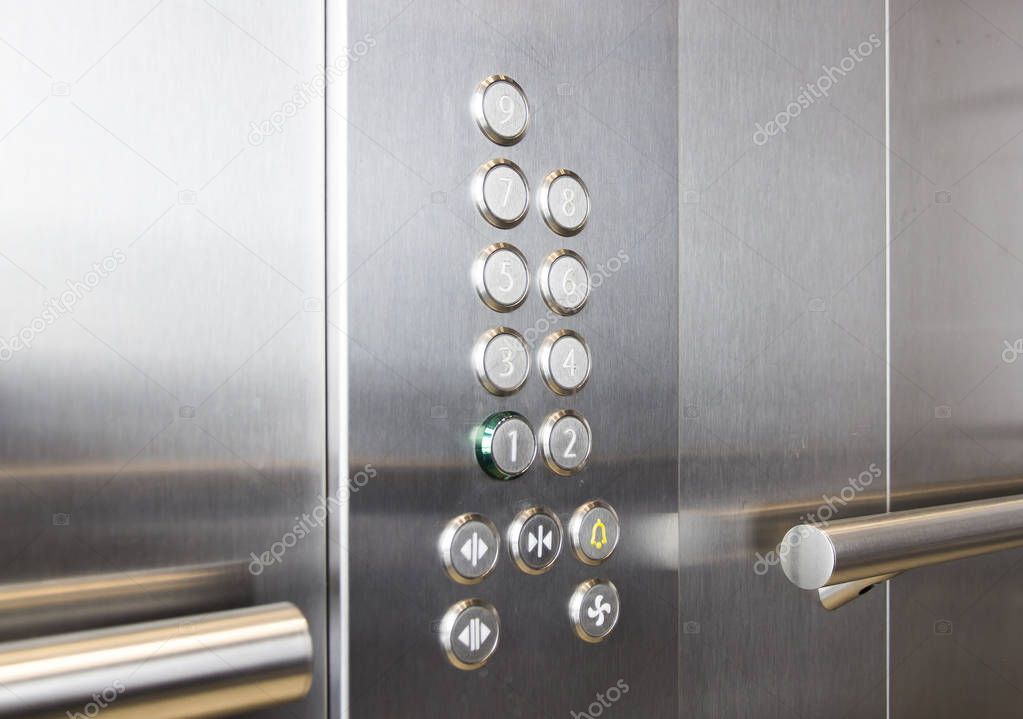 Buttons and handrail in metal elevator
