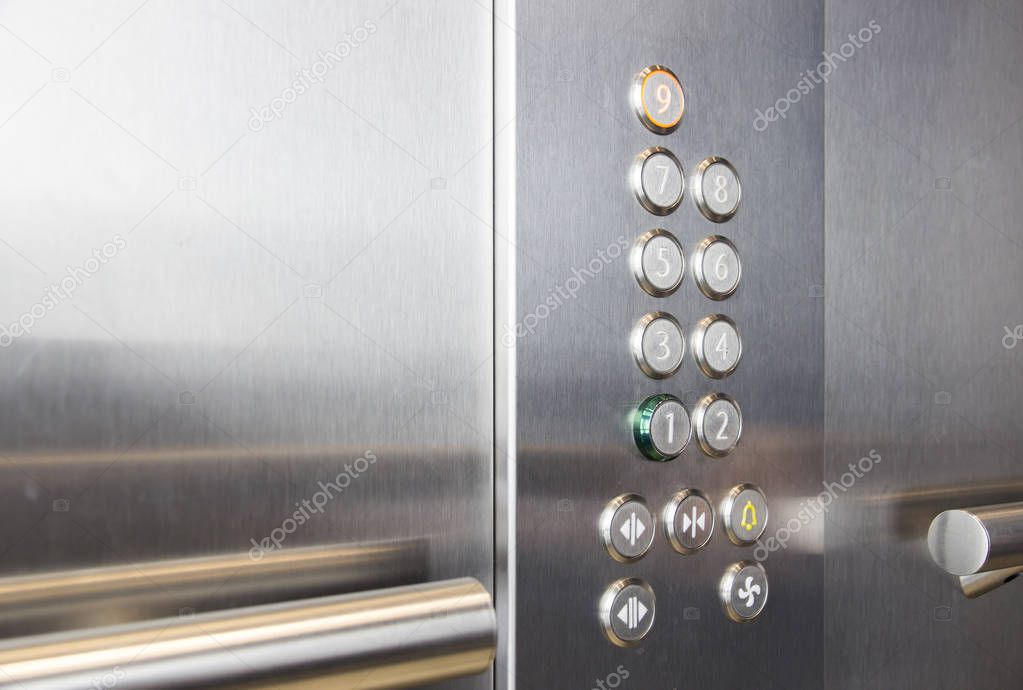 Buttons and handrail in metal elevator