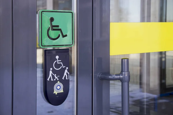 Logga på glasdörr med Schematisk framställning av personer med funktionsnedsättning i rullstol — Stockfoto