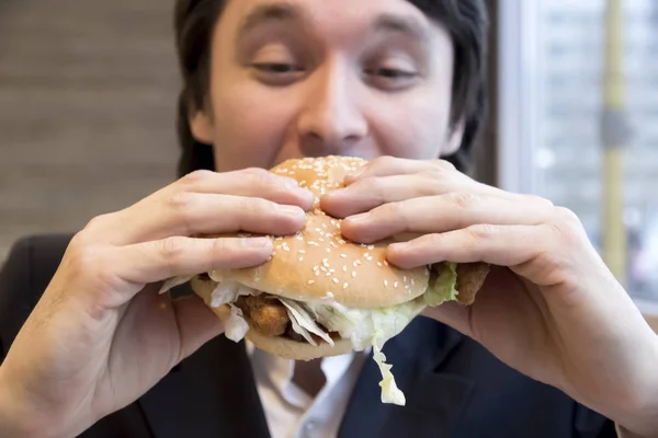 Businessman eating hamburger