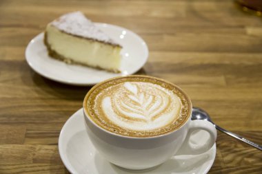 Kapuçino odak ve parçası cheesecake odak dışı