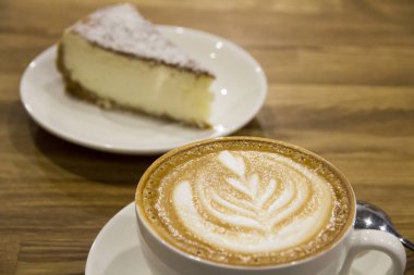 Kapuçino desenli pasta porsiyon arka plan üzerinde