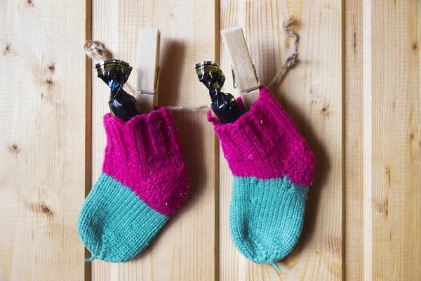Baby knitted socks on baby hang on rope on clothespins — Stock Photo, Image
