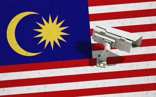 Камера видеонаблюдения на стене с окрашенным фоном флага Малайзии. Концепция политических отношений с соседями — стоковое фото
