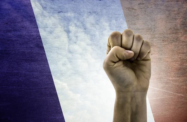 Ruce zaťaté v pěst Francouzská vlajka v pozadí — Stock fotografie