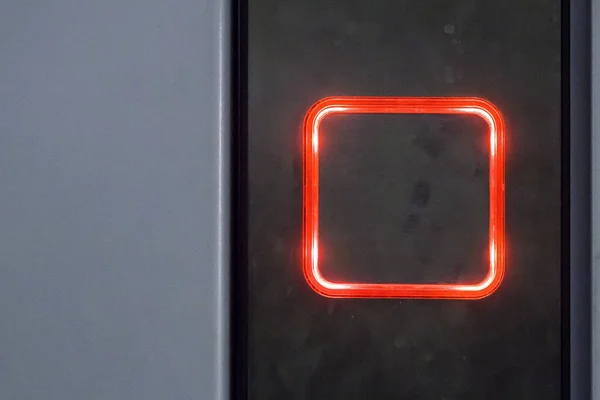 Square button with red backlight for calling elevator on metal panel — Stock Photo, Image