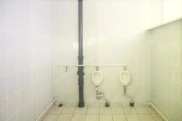 Грязные писсуары в общественном туалете для мужчин — стоковое фото