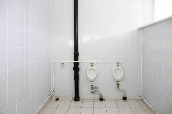 Urinoirs sales dans le mur carrelé dans les toilettes publiques se concentrant — Photo