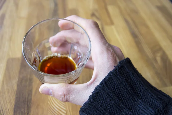 Male hand holds glass with alcoholic drink — Stock Photo, Image