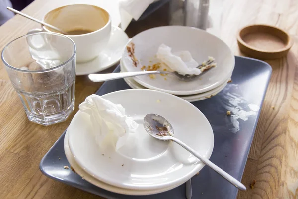 Despreocupadamente puso platos sucios después de comer en la mesa de madera en el comedor — Foto de Stock
