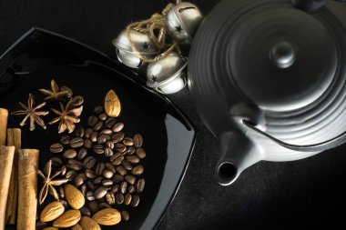 Kahve çekirdekleri bir çaydanlık ve çan siyah bir arka plan ile baharat