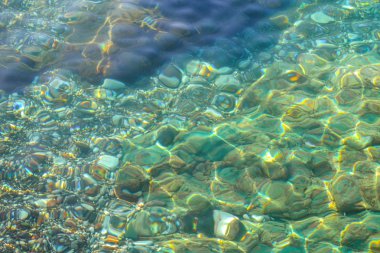 Sualtı deniz taşları, dalgaların ve dalgalar, güzel desen şeffaf temiz su ile yüzey