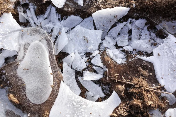 Glace cassée sur un chemin de terre de campagne. De la flaque congelée. Contexte abstrait — Photo