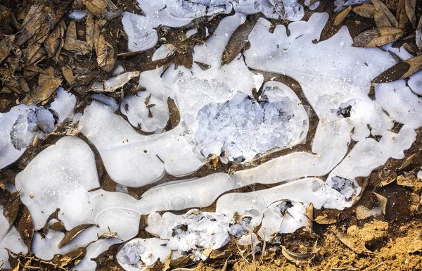 Glace cassée sur un chemin de terre de campagne. De la flaque congelée. Contexte abstrait — Photo