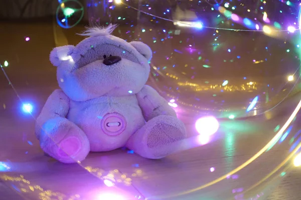 Egy játékmackó, színes fényekkel körülvéve. Absztrakt mese mágia háttér. — Stock Fotó