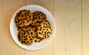Tahta masada çikolata parçacıklı yulaflı kurabiyeler. Üst görünüm